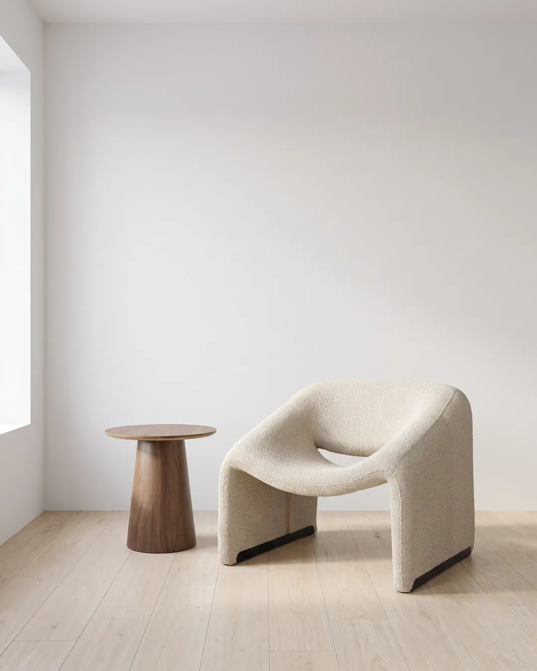 Sillón Bella greige de bouclé junto a la Mesa Lateral Padar de nogal en una sala blanca con piso de roble