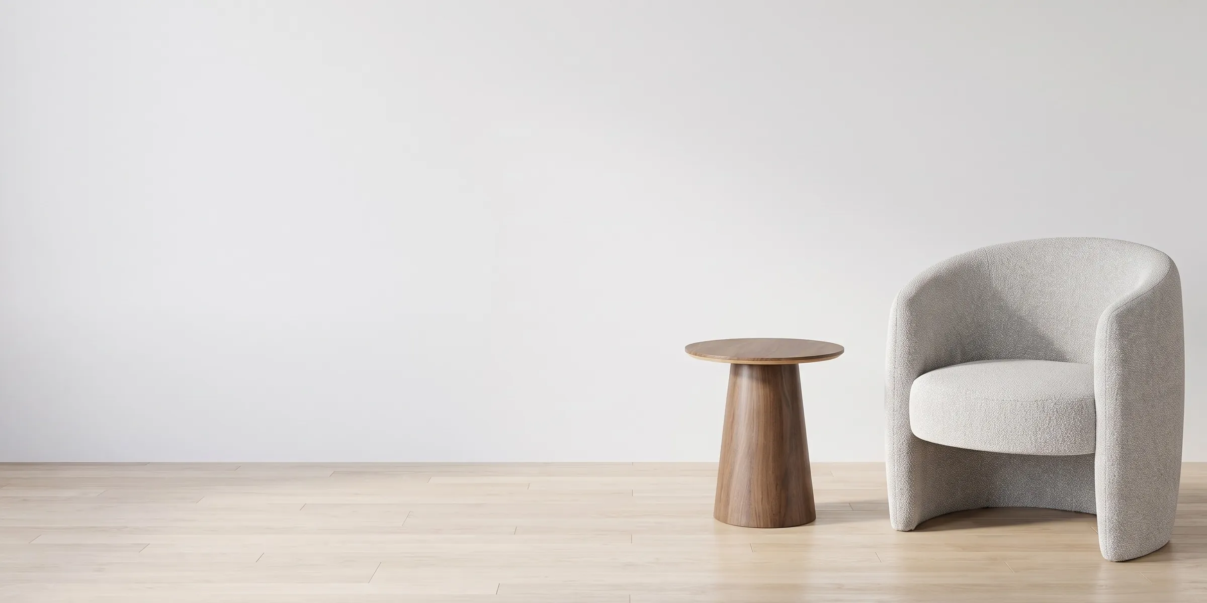Sillón Tavolara gris de bouclé junto a la Mesa Lateral Padar de nogal en una sala blanca con piso de roble